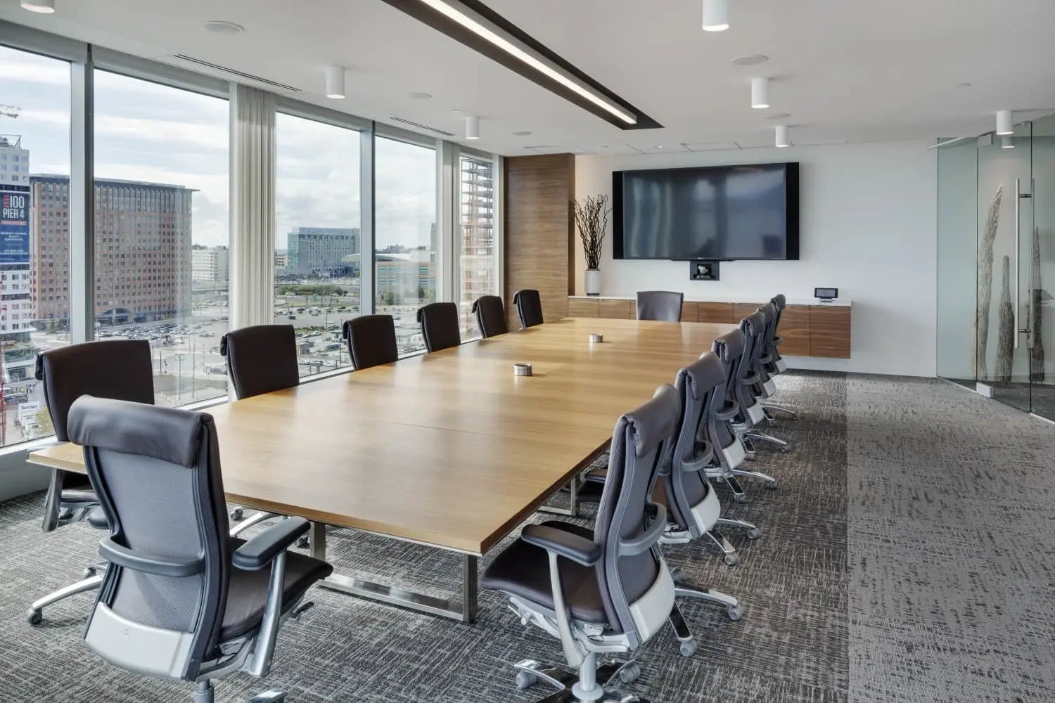 Large executive boardroom with glass walls, utilizing SIMITIE 32-element DSP microphone array with Sound Curtain technology for acoustic echo cancellation.